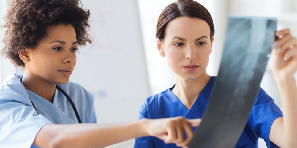 Radiologic Technology- two females holding an x-ray and discussing it